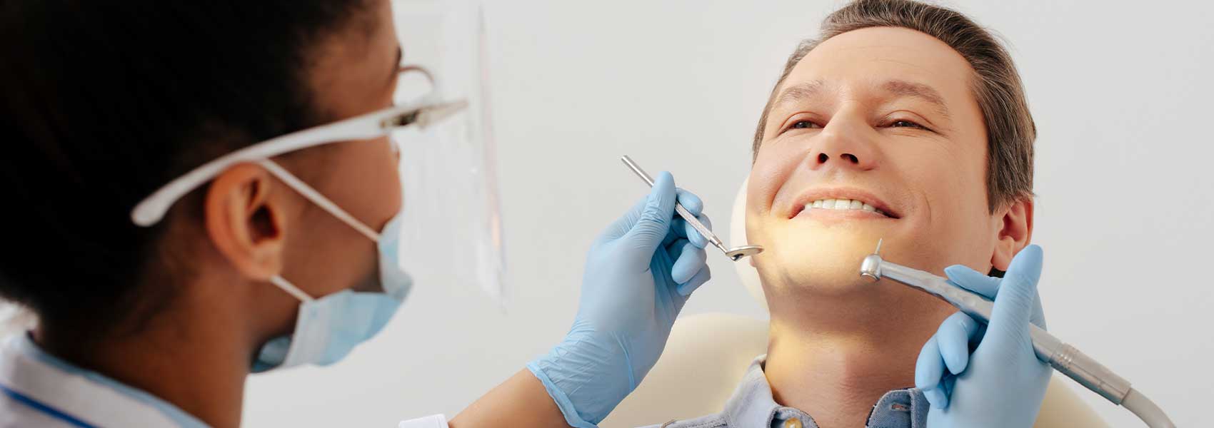 A dentist prepares to treat her patient